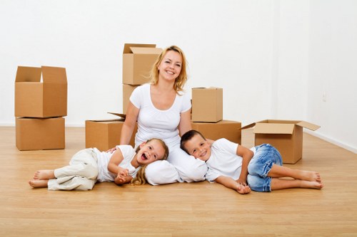 Helper carrying boxes during a residential move in Enfield